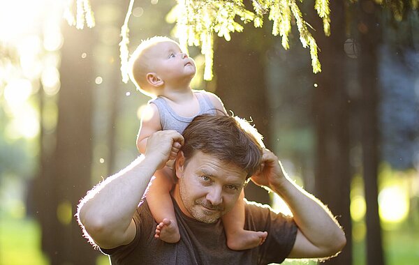 Vater trägt Baby auf den Schultern