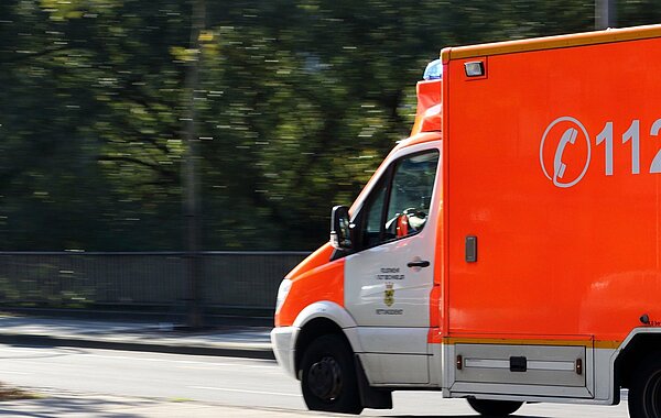 112 Rettungswagen fährt auf der Straße. Halb im Bild.