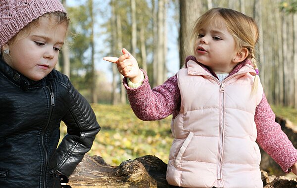 Zwei kleine Kinder im Freien diskutieren