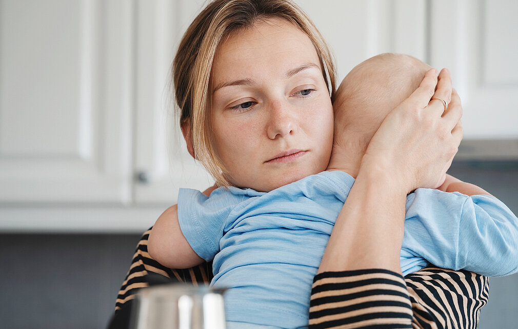 Traurige Mutter hält Baby auf dem Arm